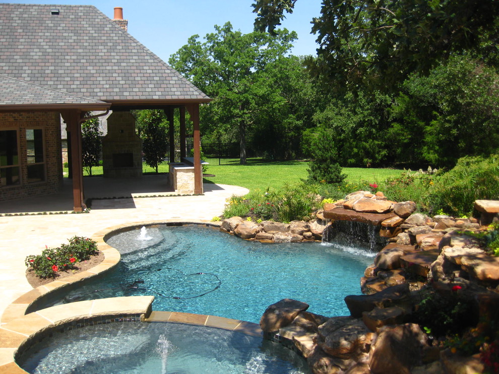 Diseño de piscina con fuente alargada clásica grande tipo riñón en patio trasero con adoquines de hormigón
