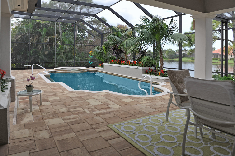 Photo of a contemporary back custom shaped hot tub in Tampa with natural stone paving.