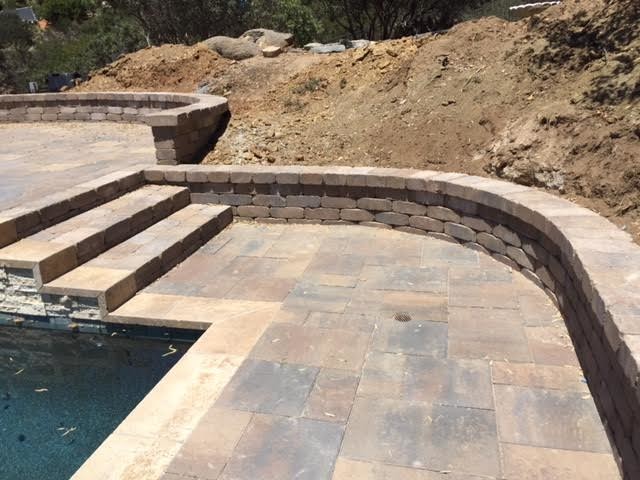 Foto de piscinas y jacuzzis alargados tradicionales grandes rectangulares en patio trasero con adoquines de piedra natural