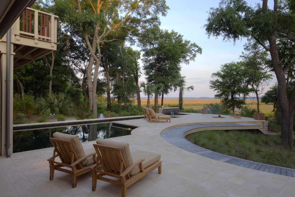 Ispirazione per una grande piscina design personalizzata dietro casa con pavimentazioni in pietra naturale e una vasca idromassaggio