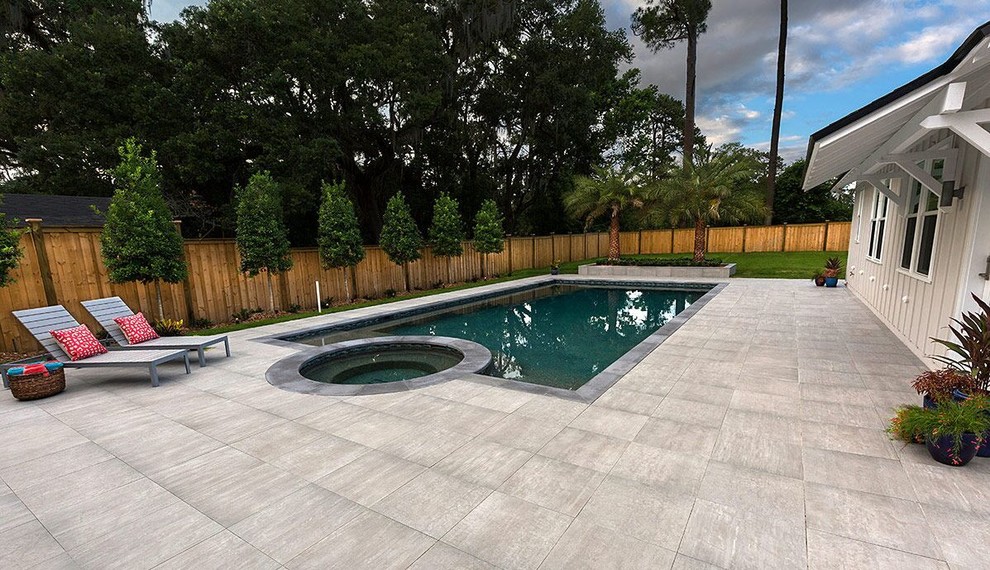 Foto de piscinas y jacuzzis alargados modernos de tamaño medio rectangulares en patio trasero con adoquines de hormigón