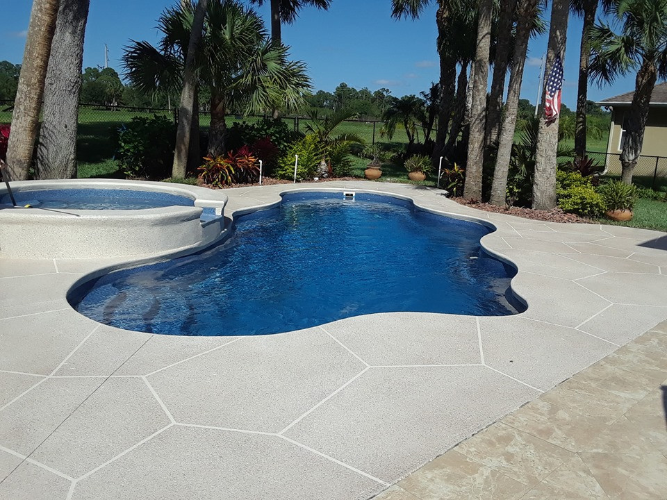 Imagen de piscina exótica de tamaño medio en patio trasero con losas de hormigón