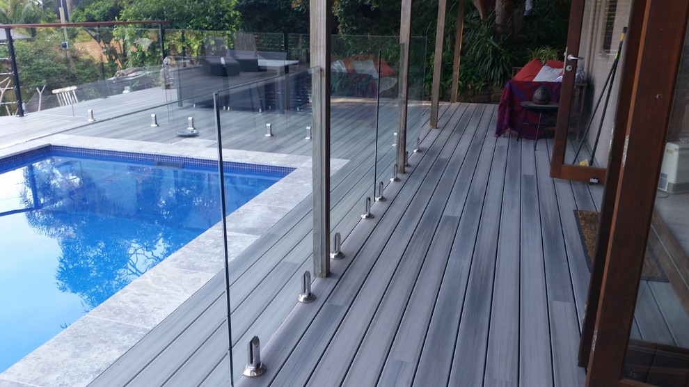 Ejemplo de piscina elevada actual grande rectangular en patio trasero con entablado