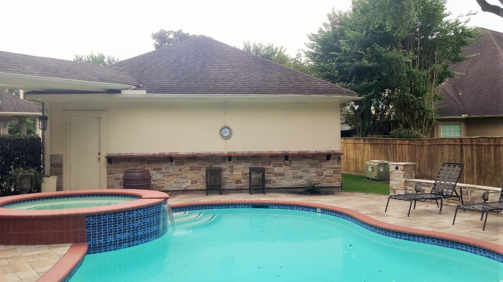 Immagine di una piscina minimal dietro casa con pavimentazioni in pietra naturale