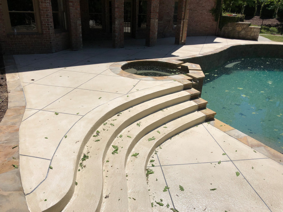Imagen de piscina con fuente elevada minimalista grande a medida en patio trasero con suelo de hormigón estampado