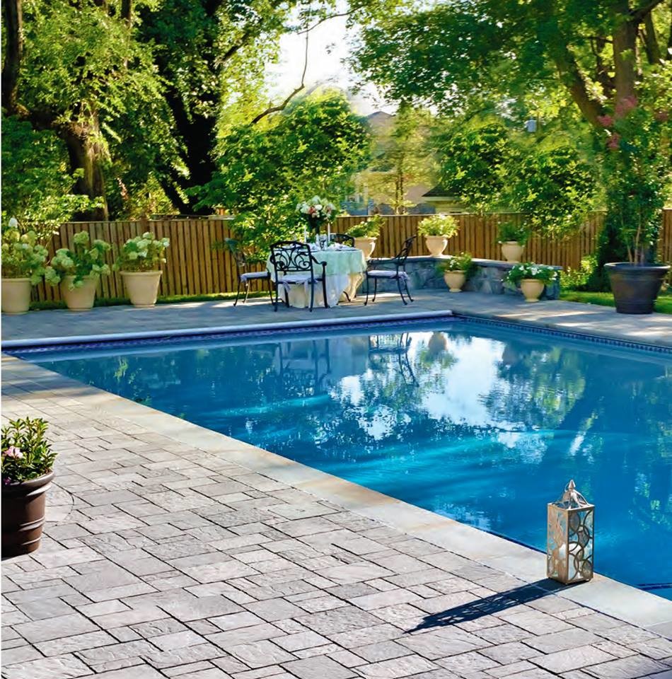 This is an example of a large classic back rectangular swimming pool in New York with natural stone paving.
