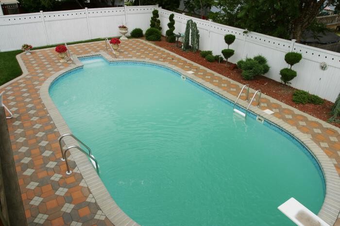Exemple d'une piscine naturelle et arrière méditerranéenne de taille moyenne et ronde avec des pavés en pierre naturelle.
