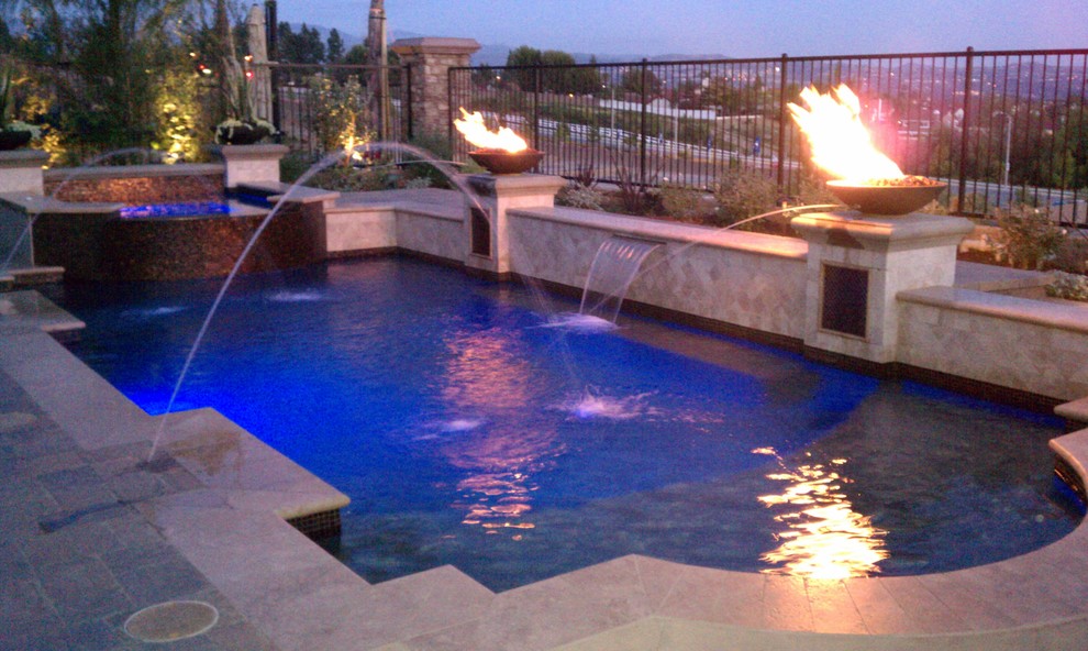 Imagen de piscina con fuente alargada actual de tamaño medio a medida en patio trasero con suelo de hormigón estampado