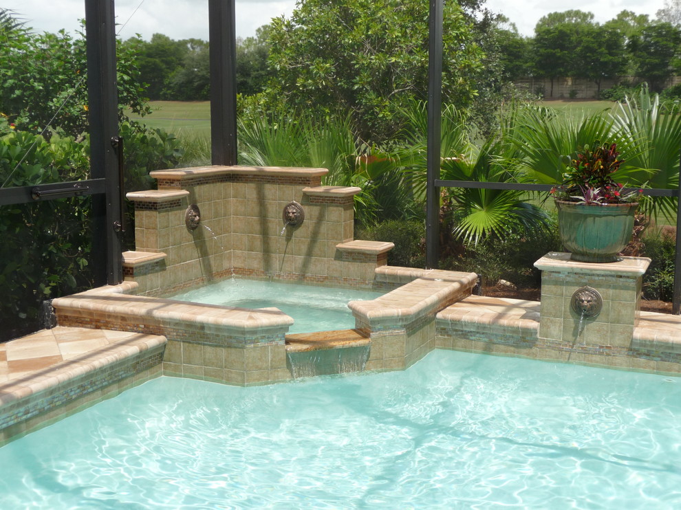 Design ideas for a mediterranean back custom shaped hot tub in Miami with concrete paving.