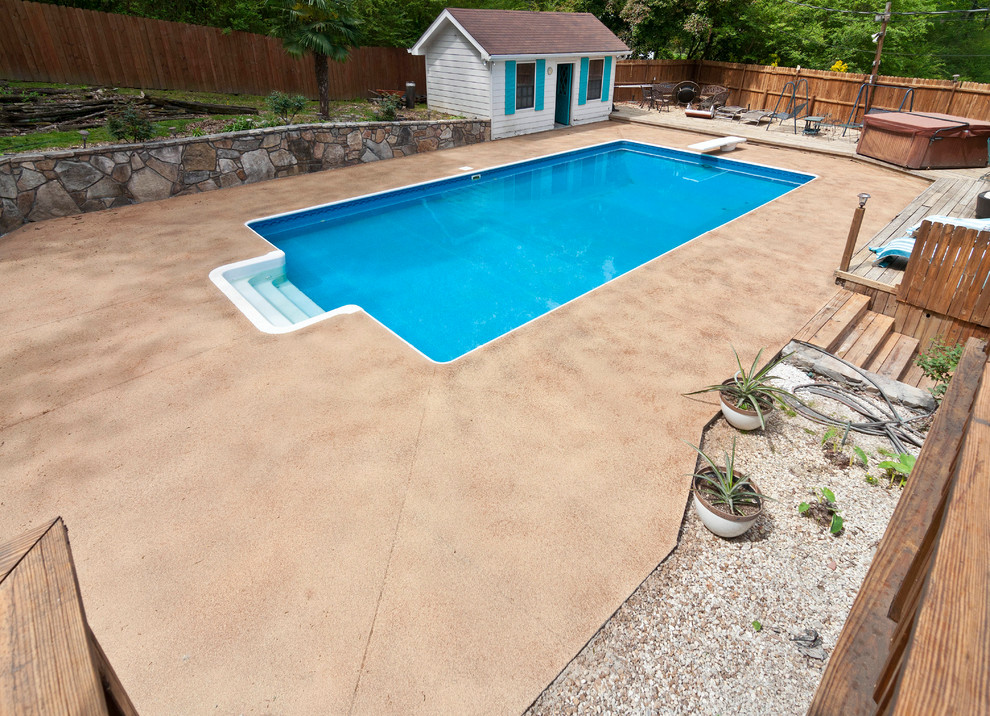 Modelo de casa de la piscina y piscina costera rectangular en patio trasero con losas de hormigón