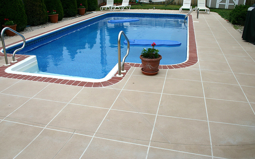 Ispirazione per una piscina monocorsia tradizionale rettangolare di medie dimensioni e dietro casa con una dépendance a bordo piscina e cemento stampato