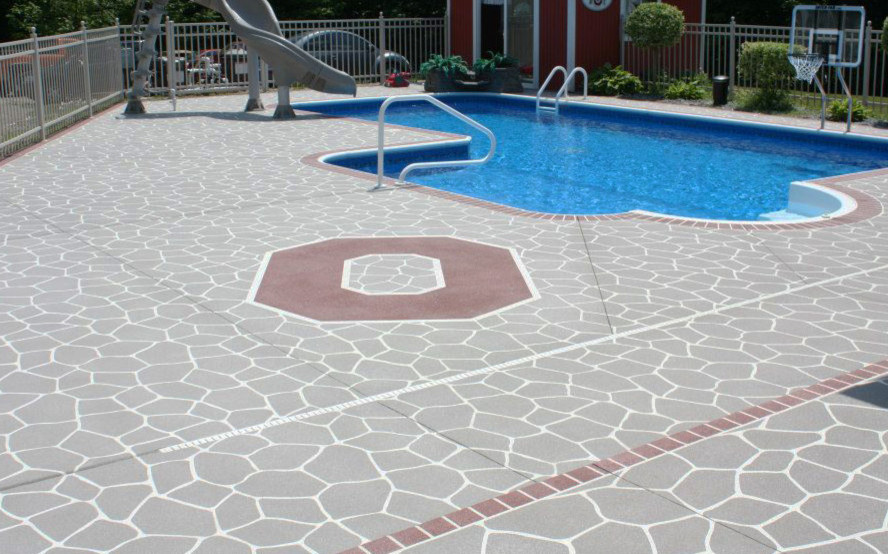 Ejemplo de piscina con tobogán alargada tradicional de tamaño medio en forma de L en patio trasero con suelo de hormigón estampado