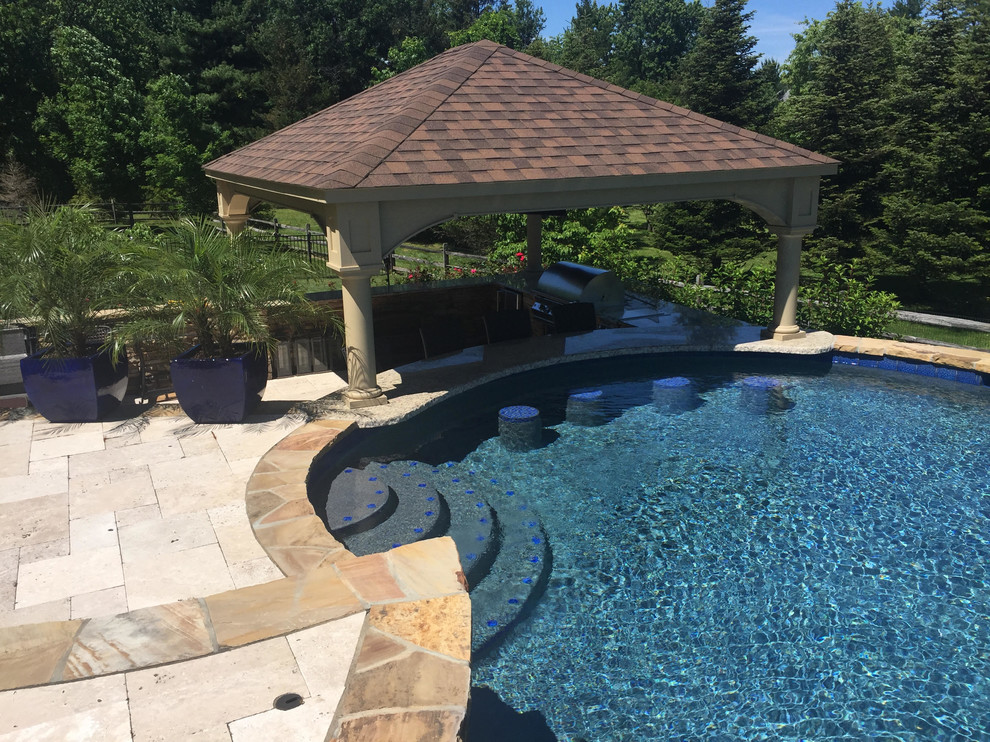 На фото: большой бассейн произвольной формы на заднем дворе в стиле рустика с покрытием из каменной брусчатки и домиком у бассейна