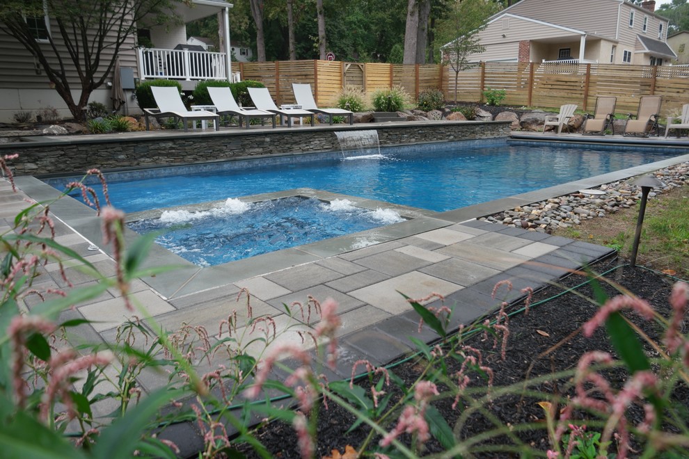 Idées déco pour une grande piscine naturelle et arrière contemporaine sur mesure avec un point d'eau et des pavés en pierre naturelle.