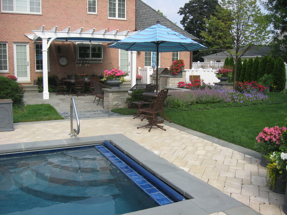 Pool - traditional backyard stone and rectangular pool idea in Chicago