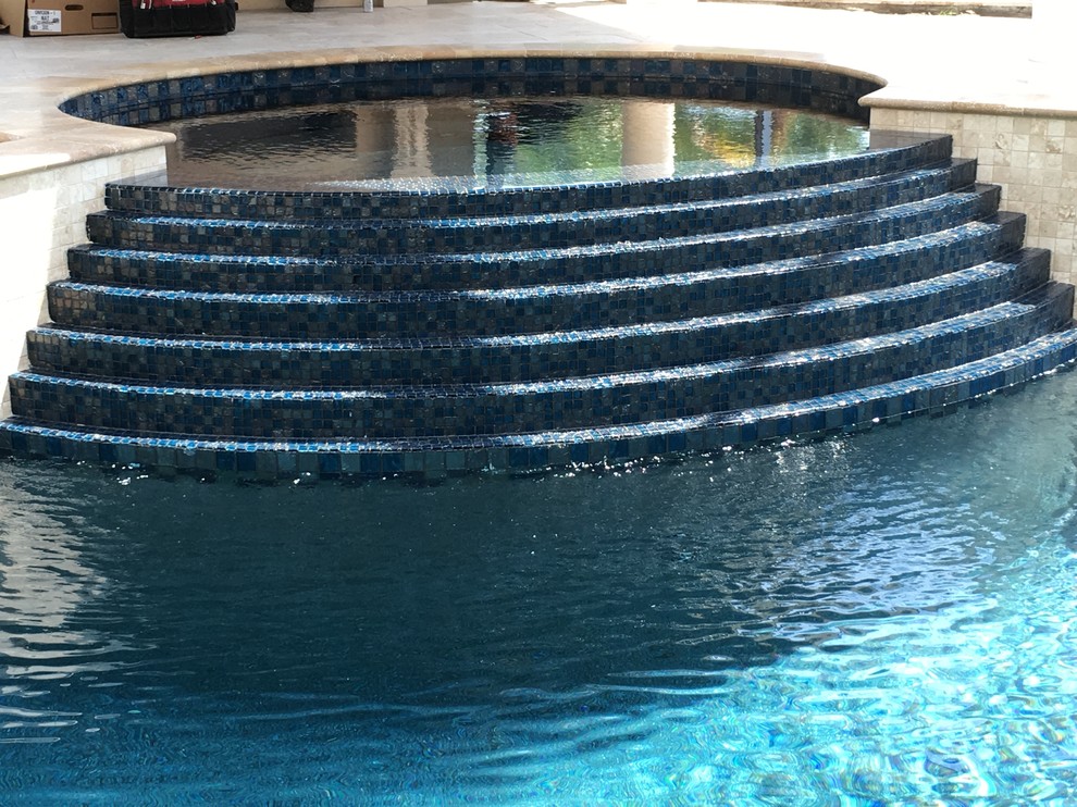 Ispirazione per una piscina naturale tradizionale personalizzata di medie dimensioni e dietro casa con una vasca idromassaggio e piastrelle