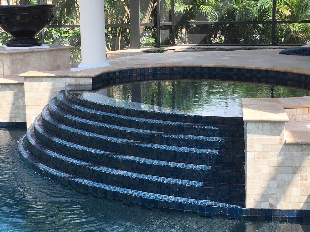 Diseño de piscinas y jacuzzis naturales tradicionales de tamaño medio a medida en patio trasero con suelo de baldosas