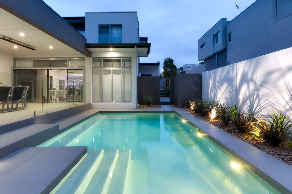 Inspiration for a large contemporary backyard stone and custom-shaped lap pool remodel in Sydney
