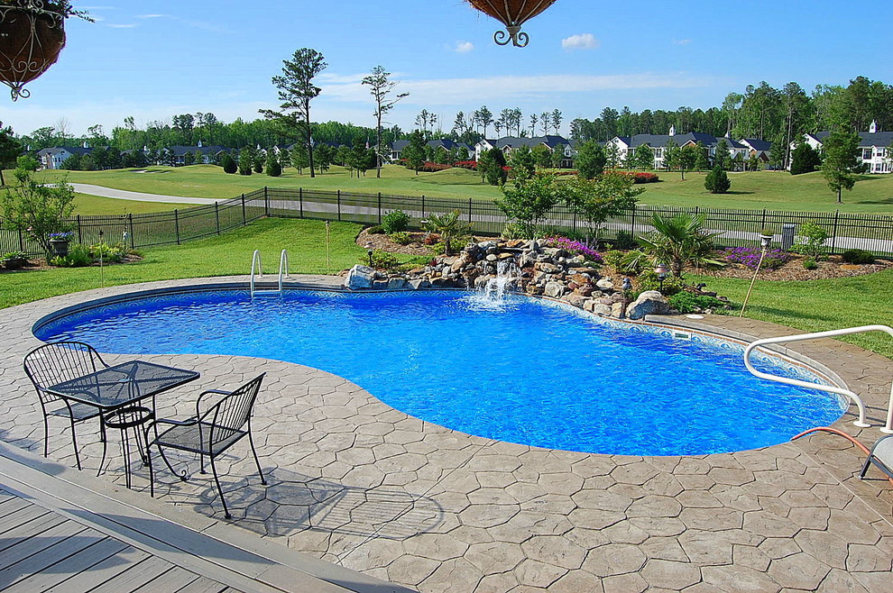 Ispirazione per una piscina monocorsia stile americano personalizzata di medie dimensioni e dietro casa con fontane e pavimentazioni in pietra naturale