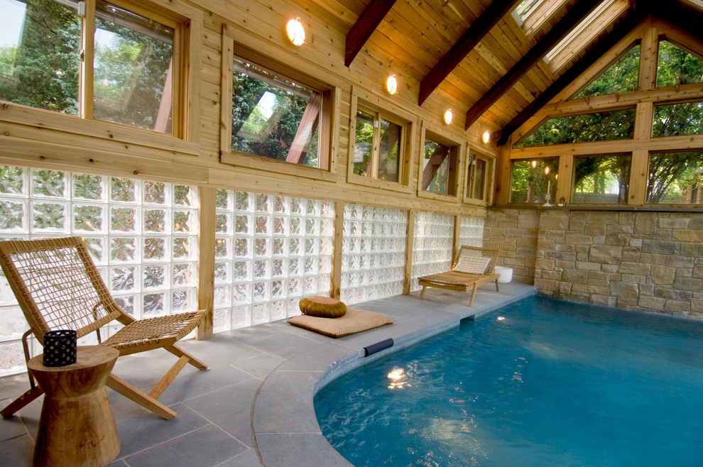 На фото: большой бассейн произвольной формы в доме в восточном стиле с домиком у бассейна и покрытием из каменной брусчатки с