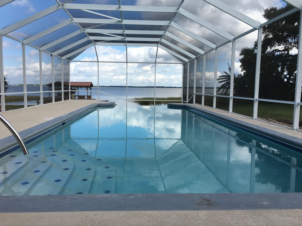 Imagen de piscina infinita marinera de tamaño medio rectangular en patio trasero con losas de hormigón