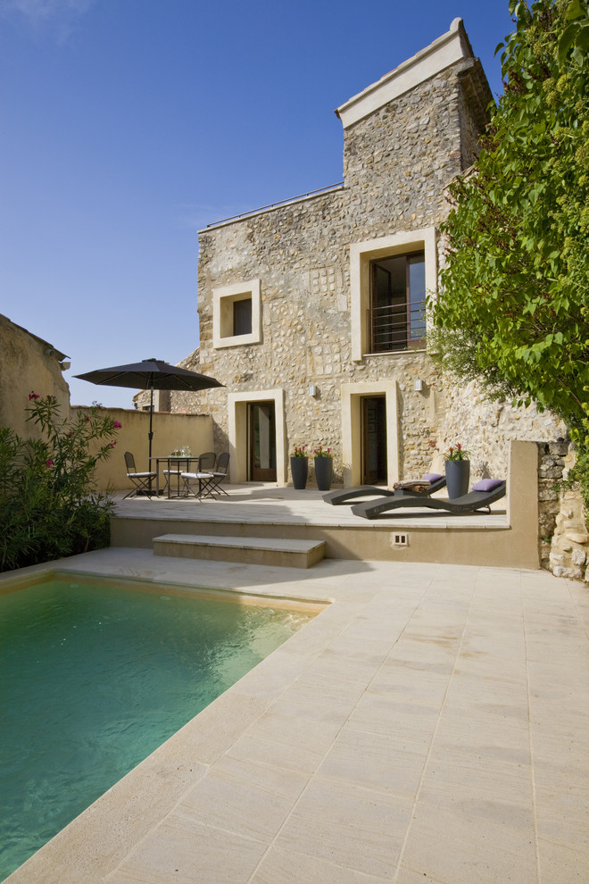 Idee per una piscina monocorsia mediterranea rettangolare con pavimentazioni in pietra naturale