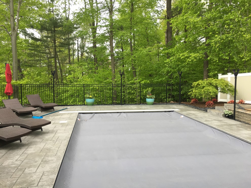 Photo of a medium sized modern back rectangular infinity swimming pool in Bridgeport with concrete paving.