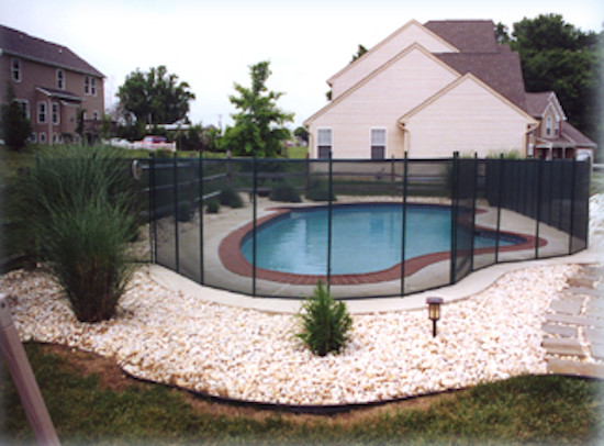 Aménagement d'une piscine arrière classique en forme de haricot de taille moyenne avec une dalle de béton.