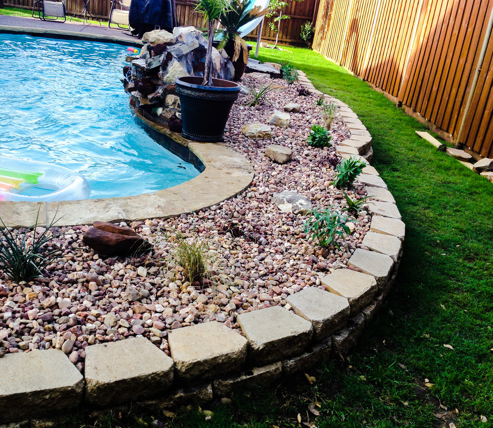 Diseño de piscina natural exótica de tamaño medio a medida en patio trasero con gravilla