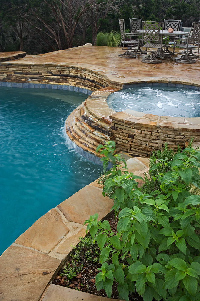 На фото: естественный бассейн среднего размера, произвольной формы на заднем дворе в стиле рустика с водной горкой и покрытием из декоративного бетона