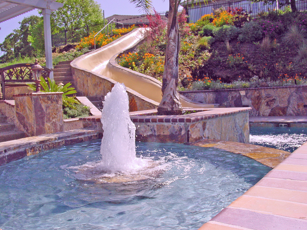 Photo of a medium sized mediterranean back rectangular lengths swimming pool in San Francisco with a water slide and stamped concrete.