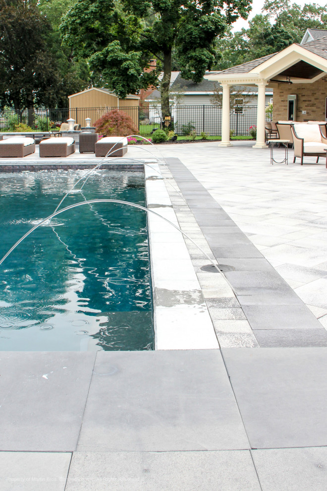 Idées déco pour un grand Abris de piscine et pool houses arrière classique rectangle avec des pavés en béton.