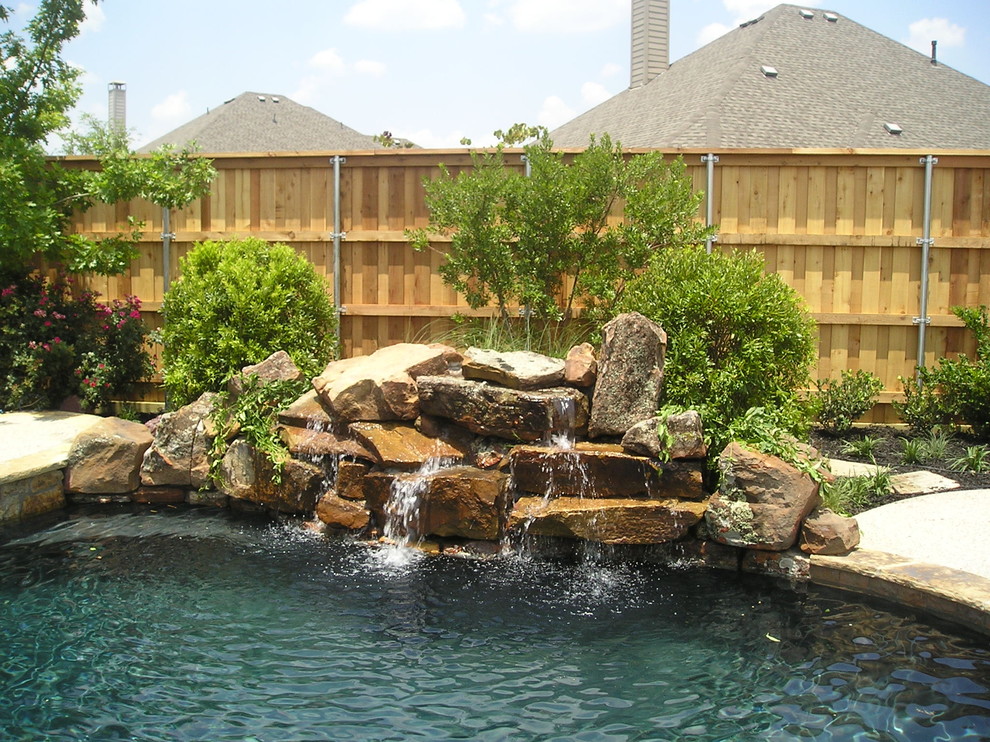Großer Rustikaler Schwimmteich hinter dem Haus in individueller Form mit Wasserspiel und Betonplatten in Dallas