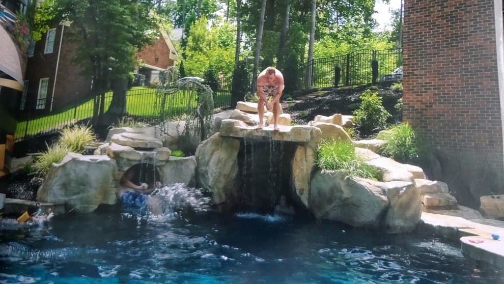 Idées déco pour une grande piscine arrière exotique sur mesure avec un point d'eau et des pavés en pierre naturelle.