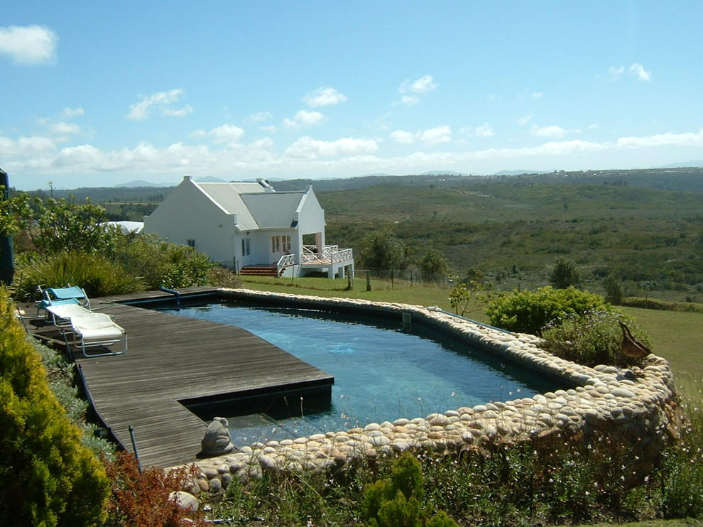 Foto di una piscina fuori terra tradizionale a "L" davanti casa con pedane