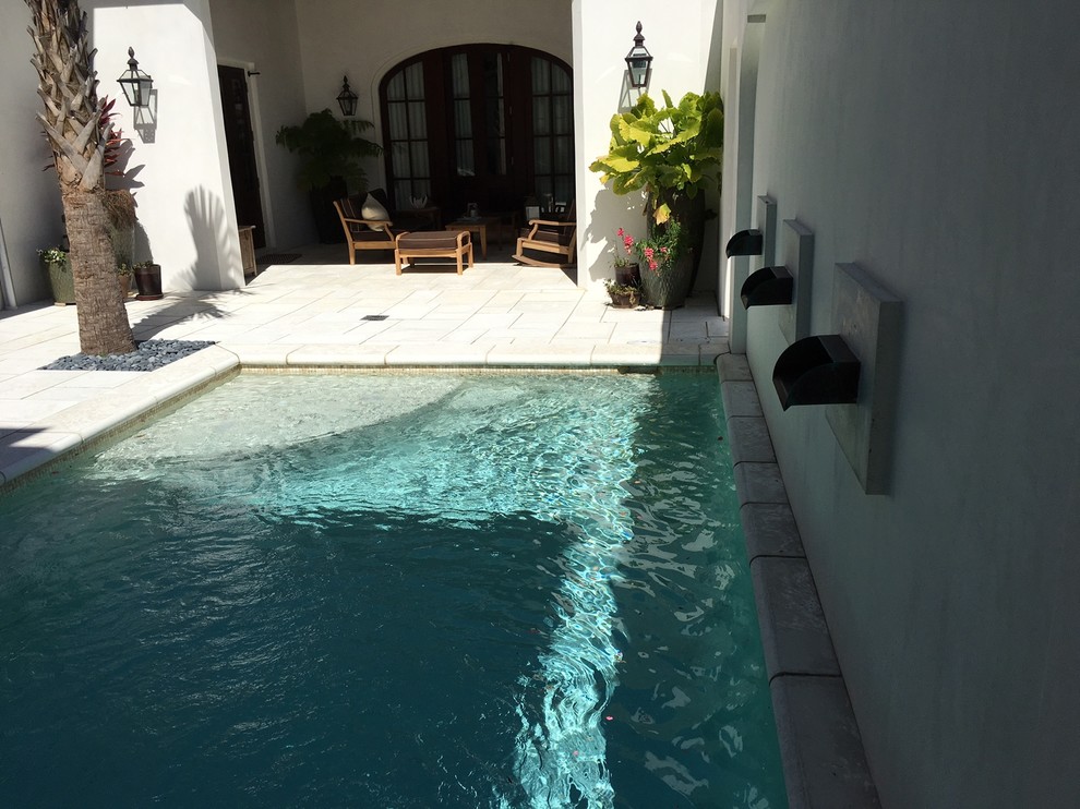 Inspiration for a large contemporary back rectangular natural swimming pool in Miami with concrete paving.