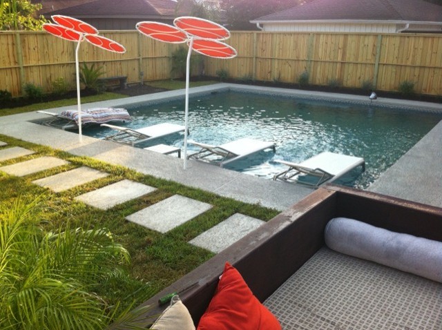 Стильный дизайн: прямоугольный бассейн среднего размера на заднем дворе в современном стиле с покрытием из бетонных плит - последний тренд