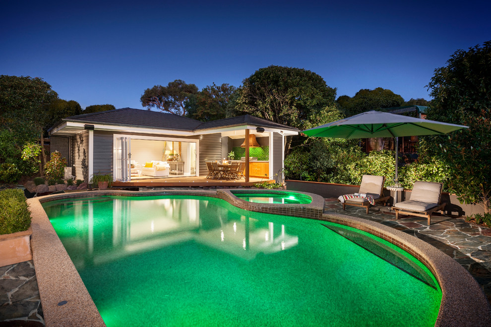 Mid-sized beach style backyard stone and custom-shaped pool house photo in Melbourne