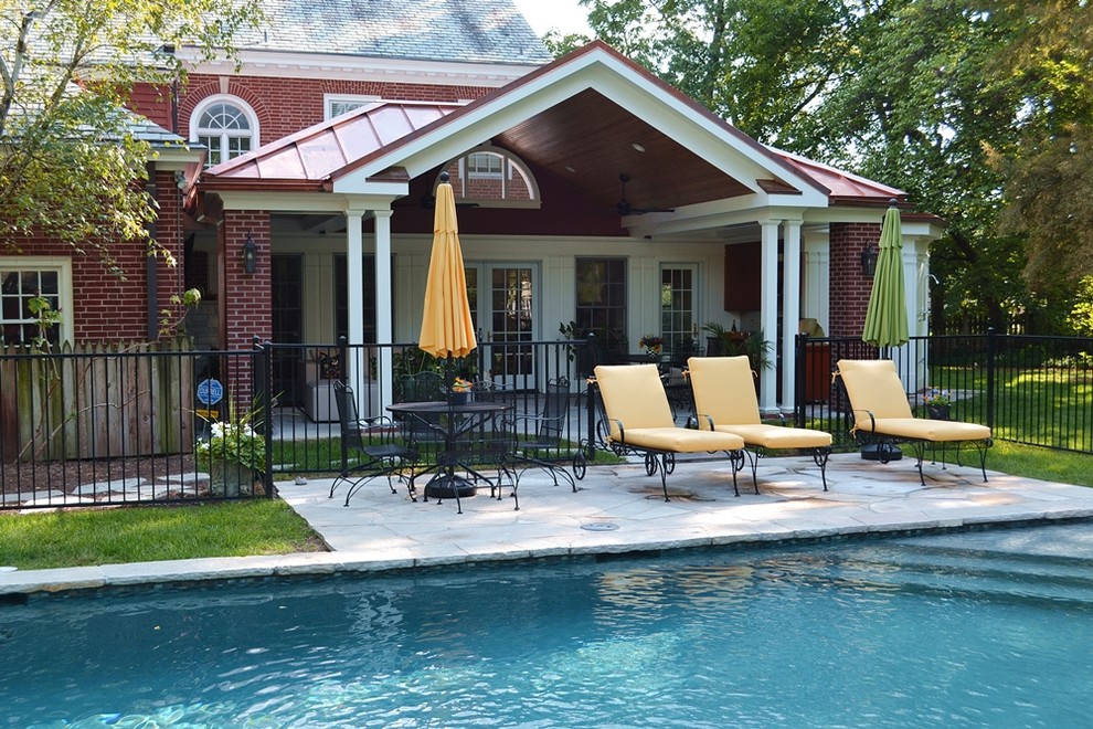 Example of a mid-sized classic backyard stone lap pool house design in St Louis