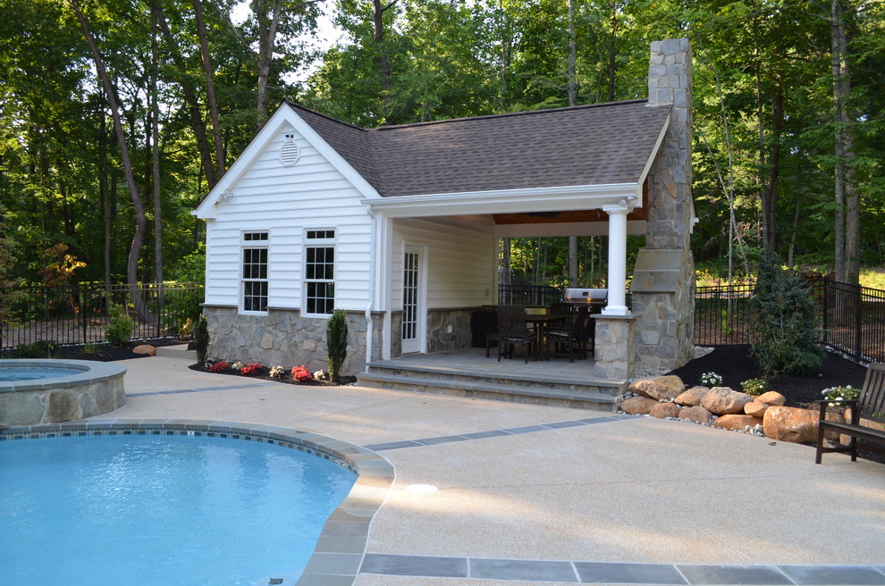 Ejemplo de piscina tradicional de tamaño medio a medida en patio trasero con losas de hormigón
