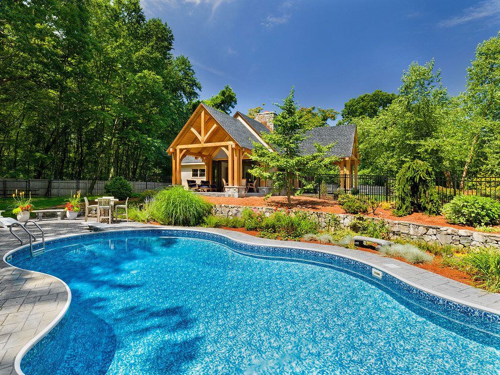 Imagen de piscina alargada campestre a medida en patio trasero con adoquines de hormigón