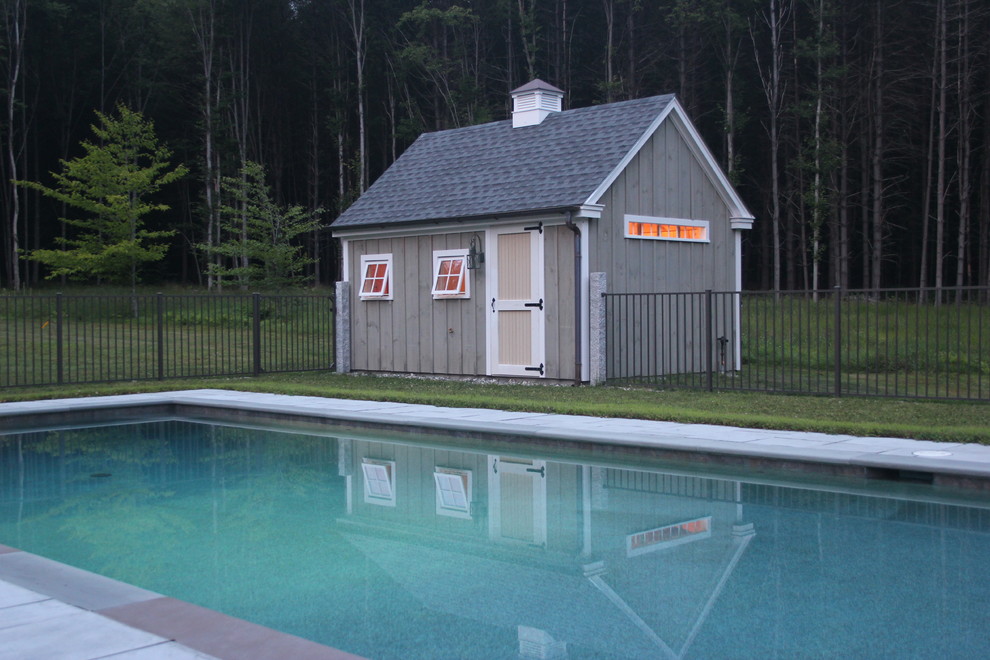 На фото: спортивный, прямоугольный бассейн среднего размера на заднем дворе в стиле кантри с домиком у бассейна и покрытием из бетонных плит с