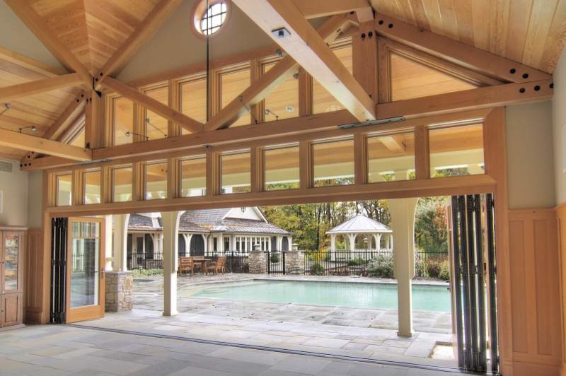 Idéer för en mycket stor klassisk pool på baksidan av huset, med poolhus och naturstensplattor