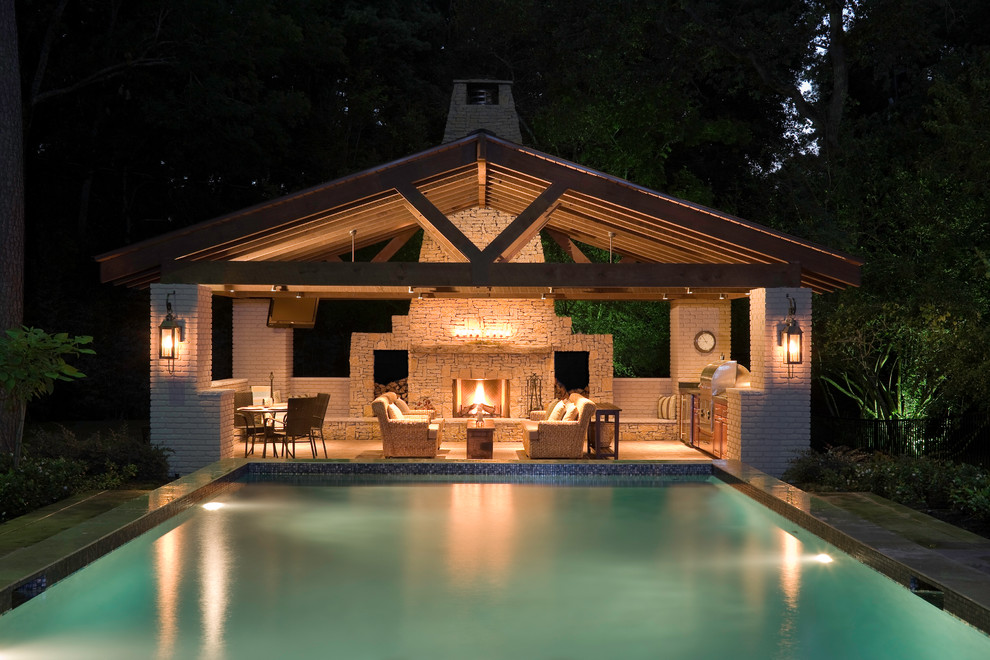 Immagine di una grande piscina design rettangolare dietro casa con una dépendance a bordo piscina e cemento stampato