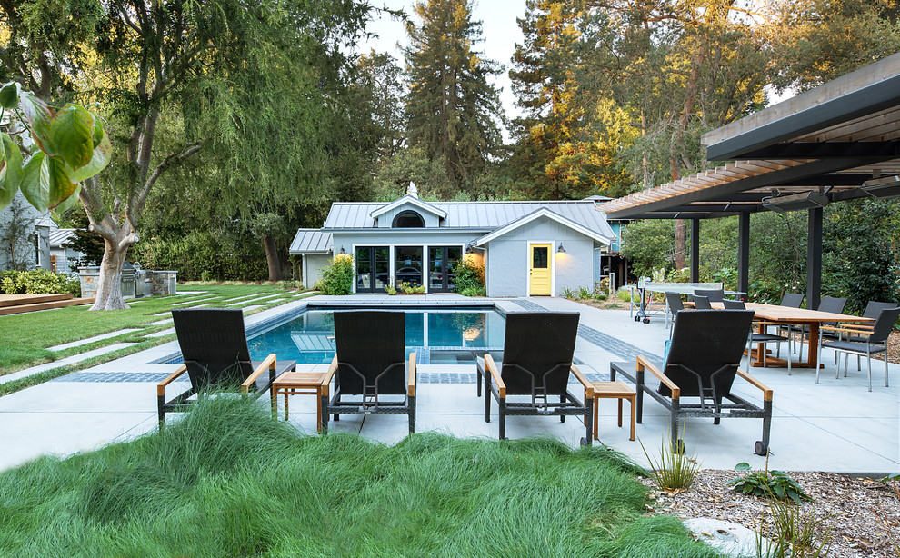 Diseño de casa de la piscina y piscina alargada clásica renovada rectangular en patio trasero con losas de hormigón
