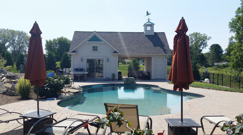 Foto de casa de la piscina y piscina natural de tamaño medio tipo riñón en patio lateral con adoquines de piedra natural