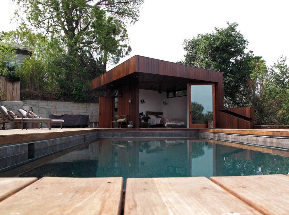 Ejemplo de piscina minimalista pequeña rectangular con entablado