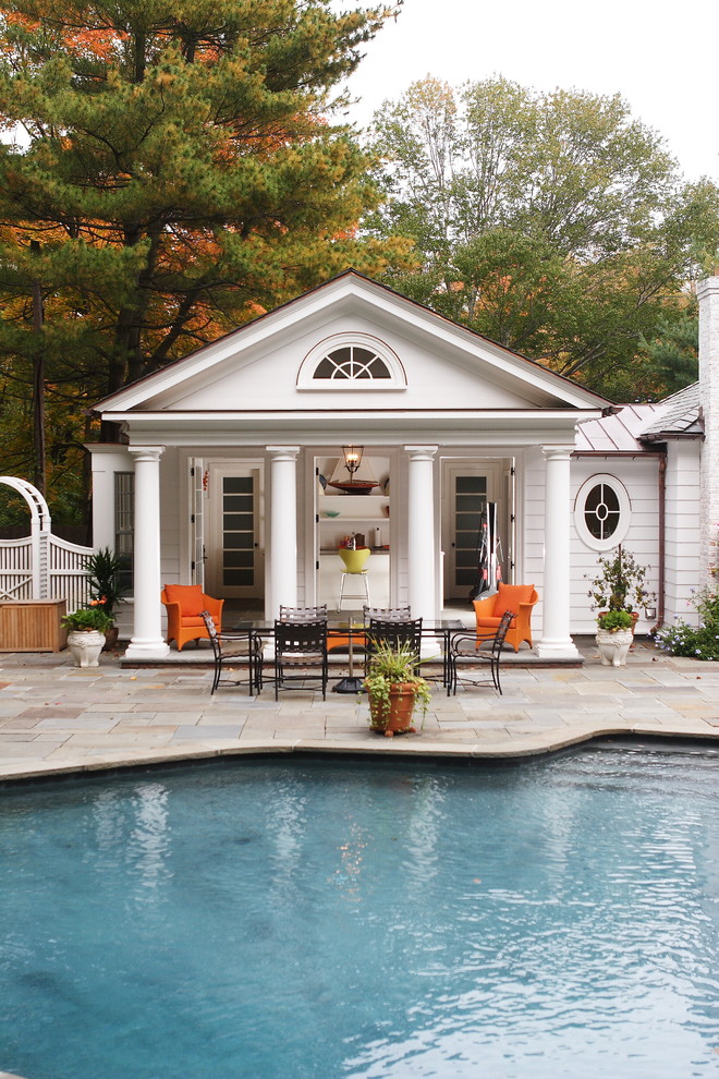 На фото: большой прямоугольный бассейн на заднем дворе в классическом стиле с домиком у бассейна и покрытием из каменной брусчатки