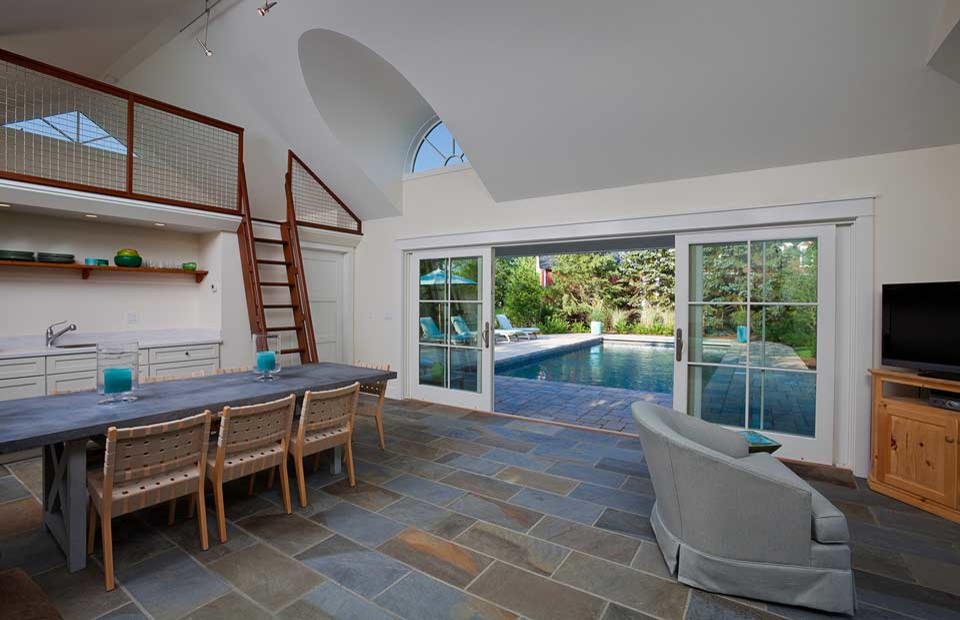 Modelo de casa de la piscina y piscina alargada tradicional pequeña rectangular en patio trasero con adoquines de hormigón