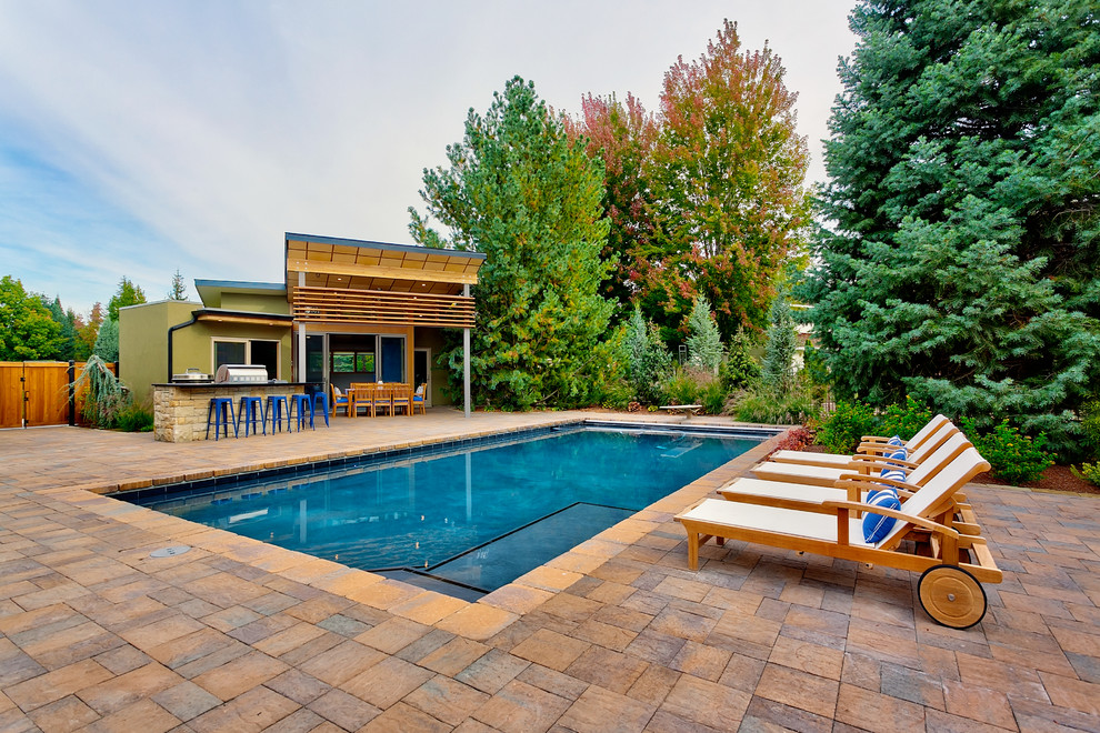 На фото: прямоугольный бассейн на заднем дворе в современном стиле с зоной барбекю